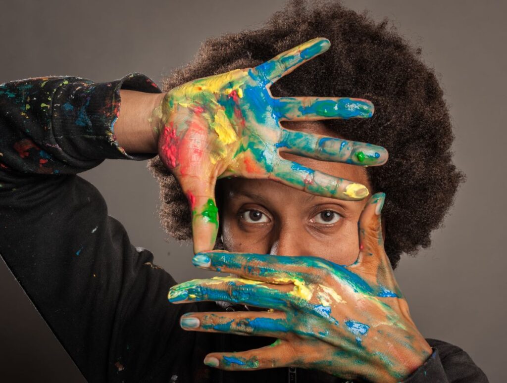 Mulher negra com as mãos pintadas de cinzento